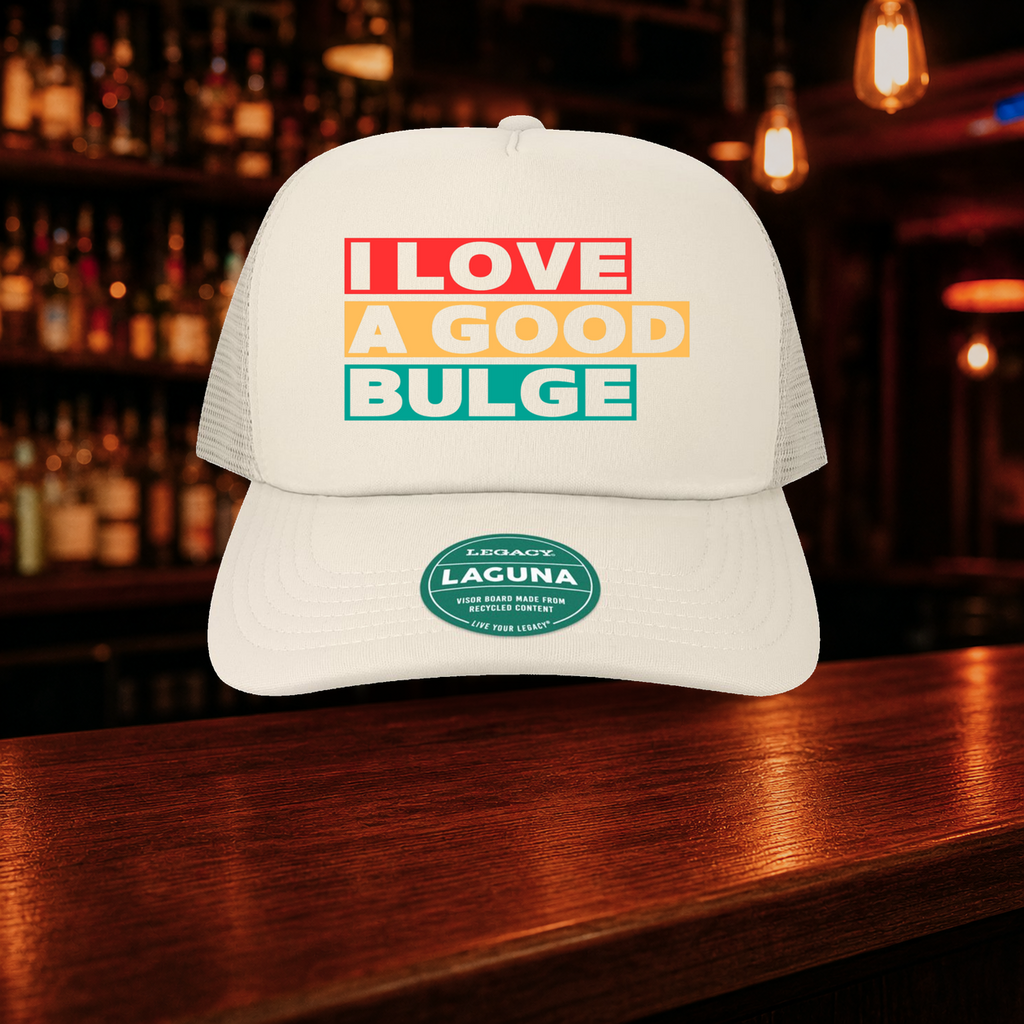 Bulge Trucker Hat — Beige variety shown against a warm after-dark bar backdrop