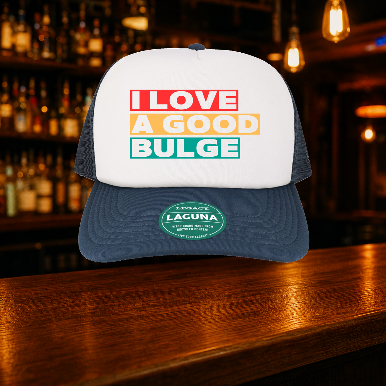 Bulge Trucker Hat — Navy variety shown against a warm after-dark bar backdrop