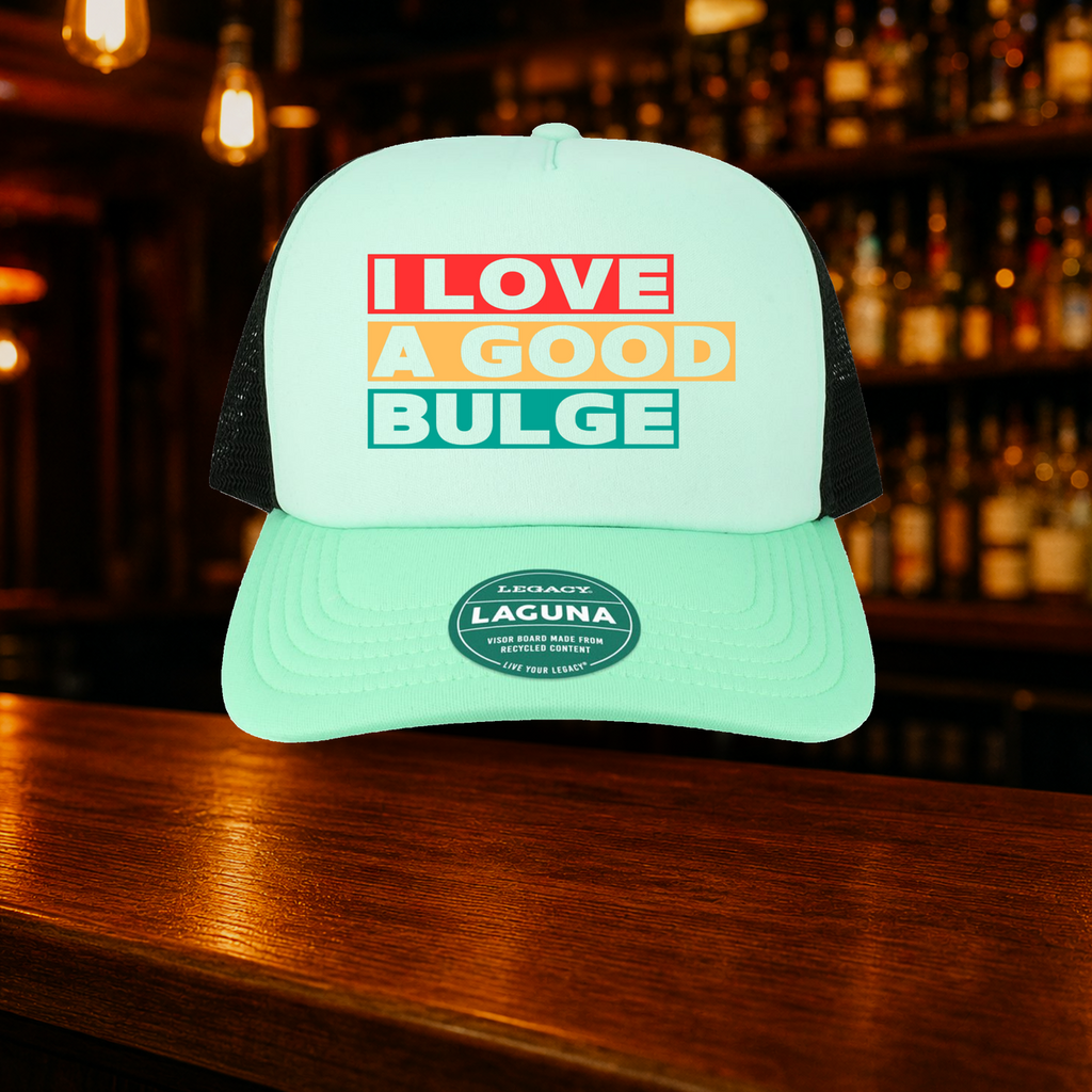 Bulge Trucker Hat — Teal variety shown against a warm after-dark bar backdrop
