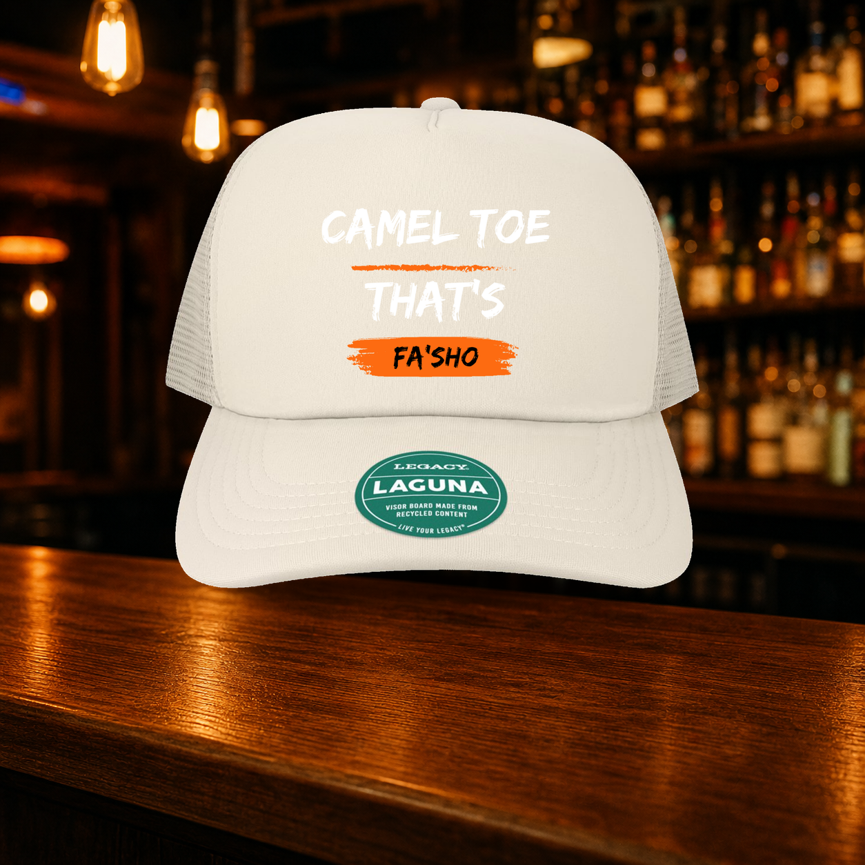 Camel Toe That's Fa'sho Trucker Hat — Beige variety shown against a warm after-dark bar backdrop