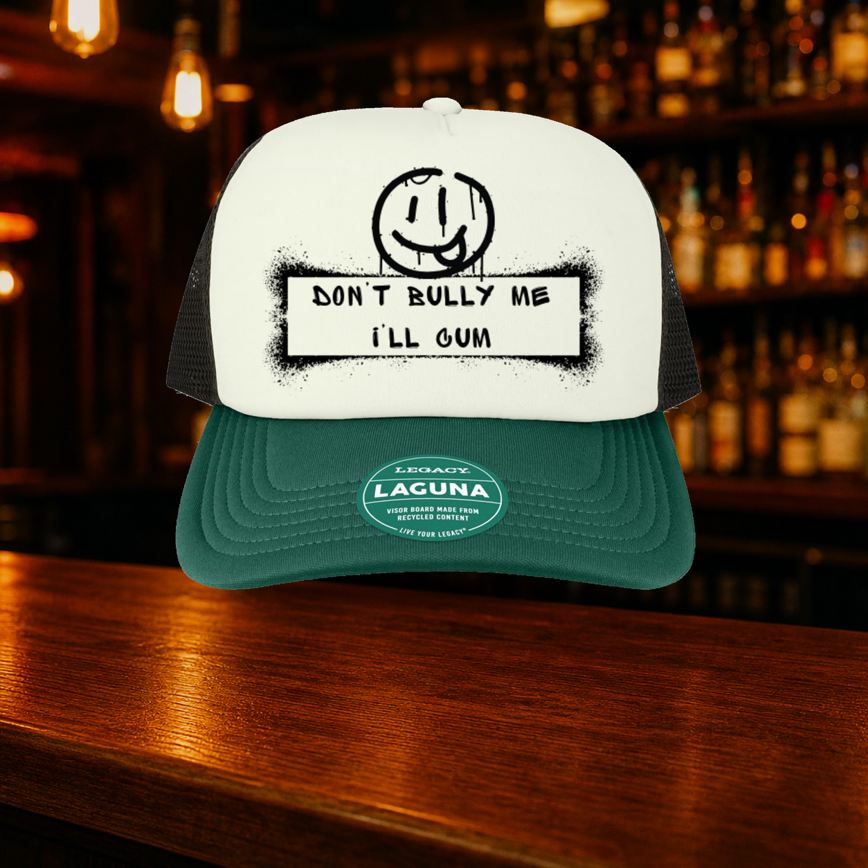 Don't Bully Me I'll Cum Trucker Hat — Green variety shown against a warm after-dark bar backdrop