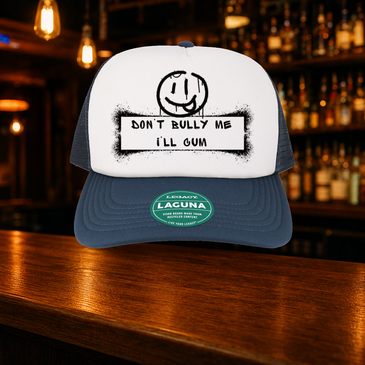 Don't Bully Me I'll Cum Trucker Hat — Navy variety shown against a warm after-dark bar backdrop