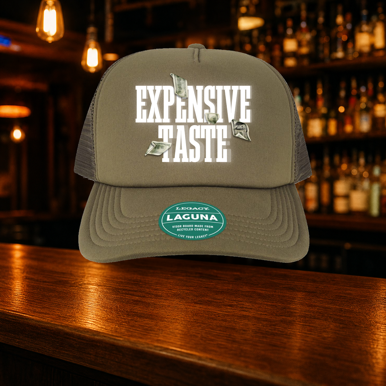 Expensive Taste Trucker Hat shown against a warm after-dark bar backdrop