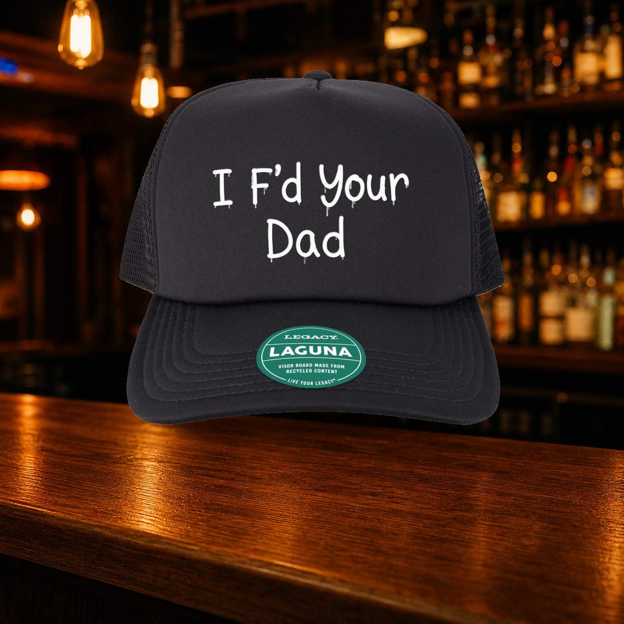 I F'd Your Dad Trucker Hat shown against a warm after-dark bar backdrop