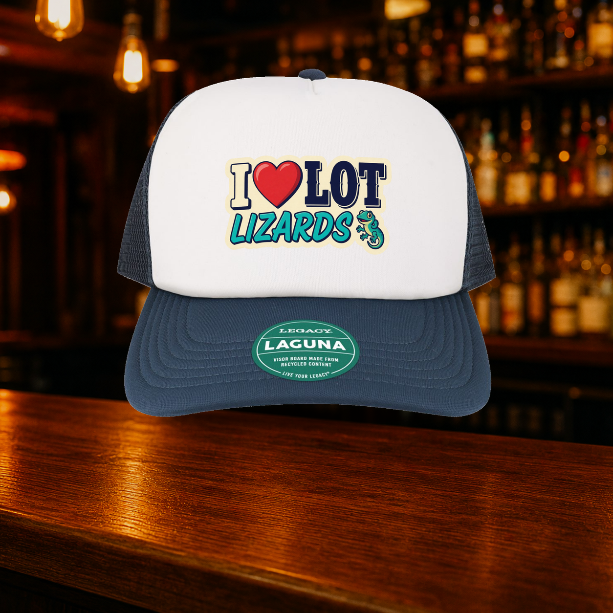 I Love Lot Lizards Trucker Hat shown against a warm after-dark bar backdrop