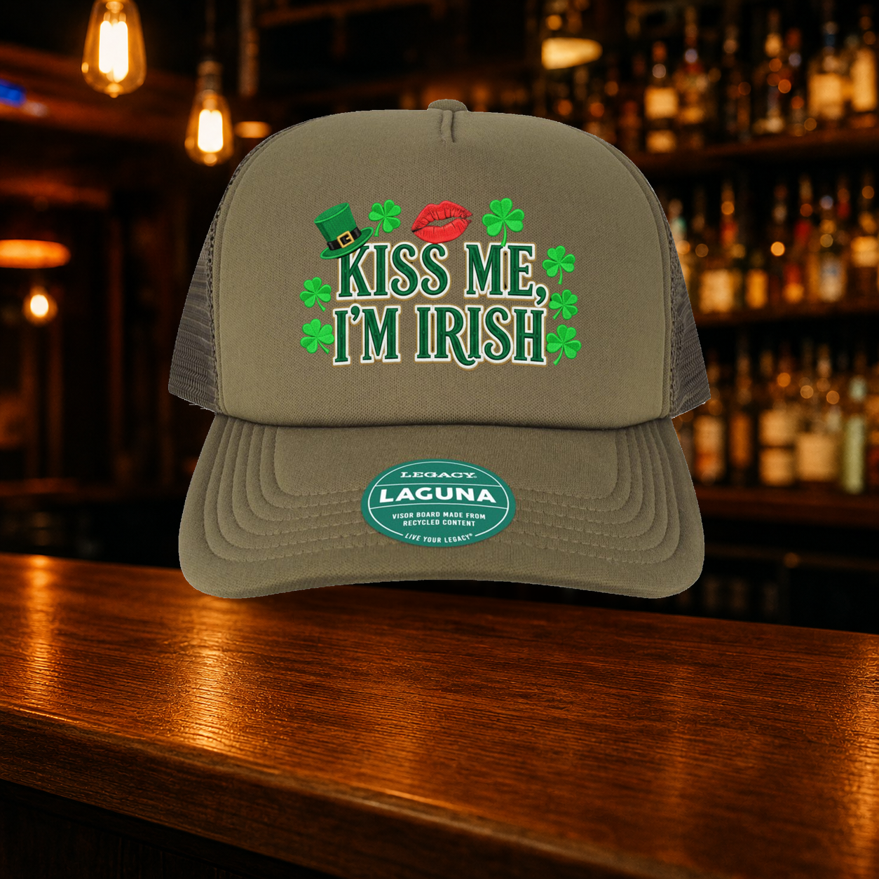 Kiss Me I'm Irish Trucker Hat shown against a warm after-dark bar backdrop