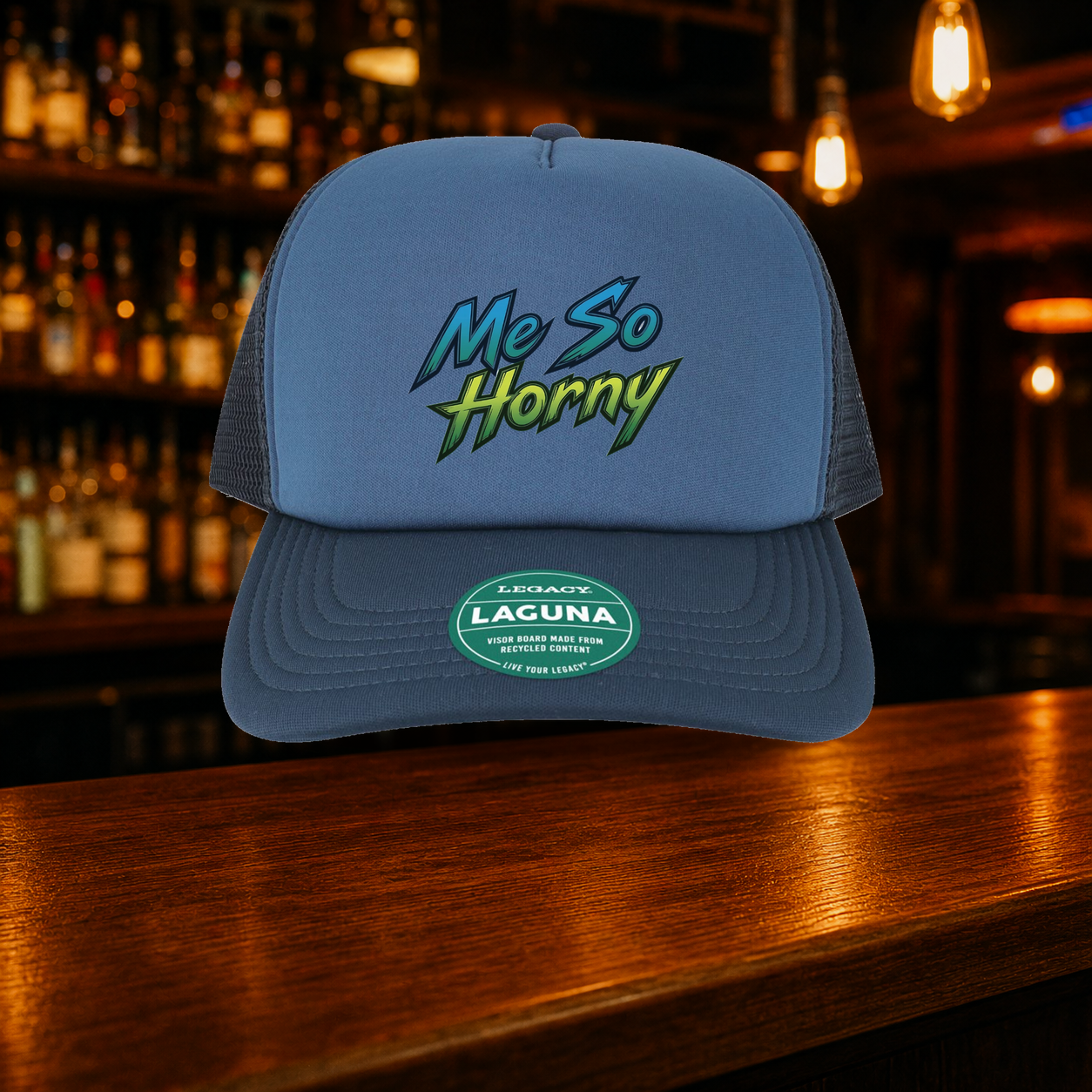 Me So Horny Trucker Hat — Blue variety shown against a warm after-dark bar backdrop