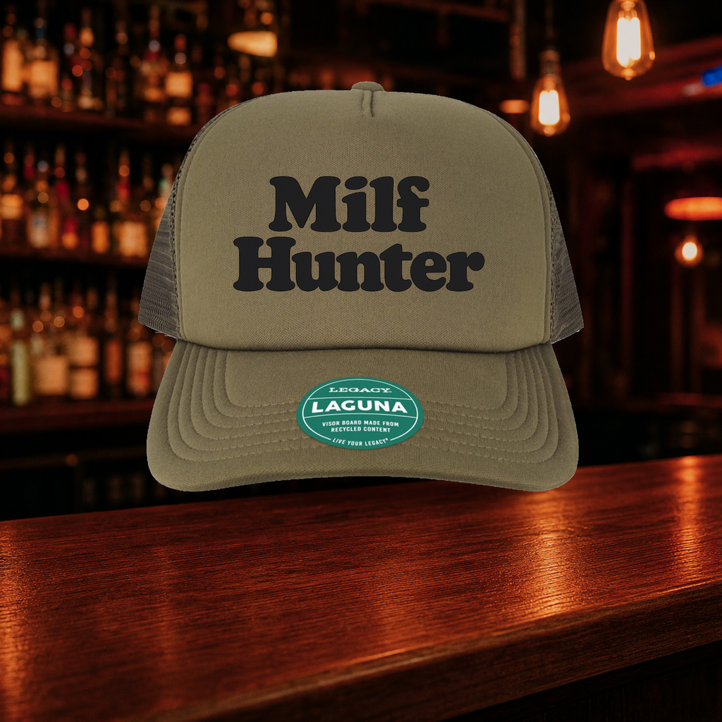 Milf Hunter Trucker Hat — Olive variety shown against a warm after-dark bar backdrop