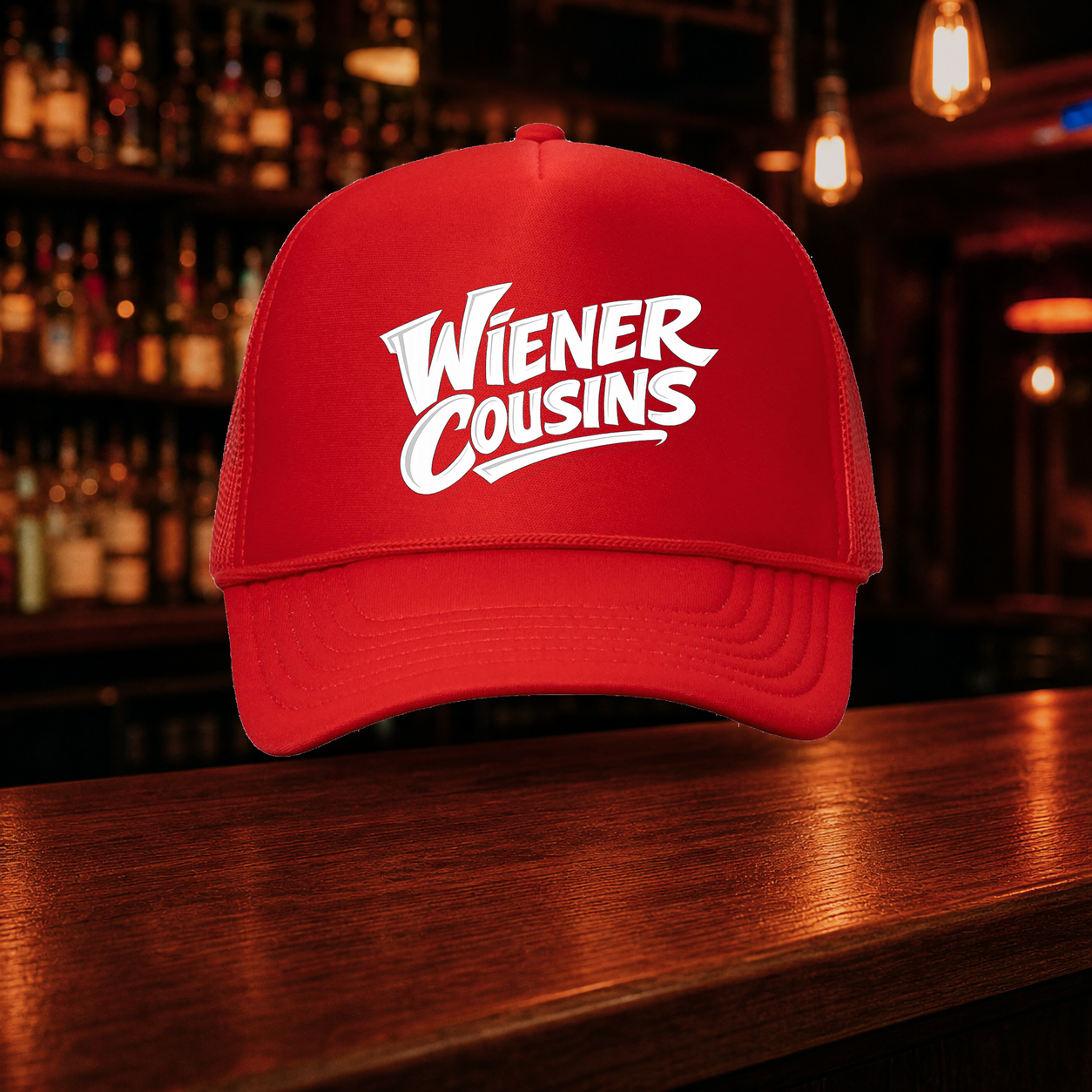Weiner Cousins Double Snap Trucker Hat shown against a warm after-dark bar backdrop