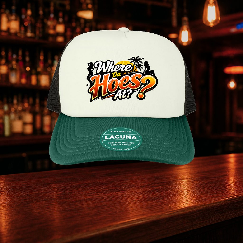Where Da Hoes At? Trucker Hat — Green variety shown against a warm after-dark bar backdrop